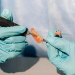 close-up of a gloved dental technician working on a prosthetic tooth in his lab