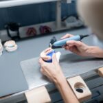 Dental technician doing denture polishing in her office