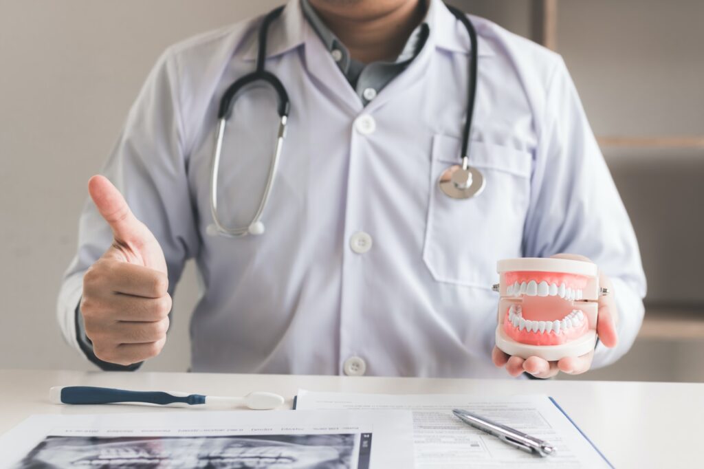 Dentist showing thumb up in office room.