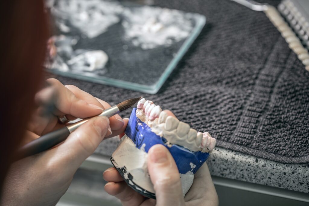 Woman hand painting denture